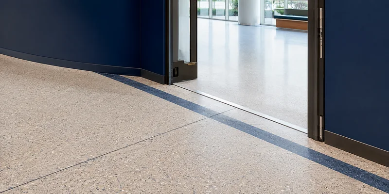 Movement joint aligned with a design band in seamless polymer terrazzo flooring
