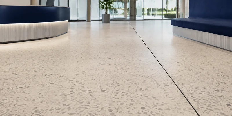 Seamless resin flooring with a retained movement joint in a modern commercial lobby