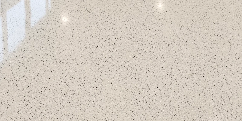 Polymer terrazzo floor coating with fine colored aggregate and a light mineral-textured finish.