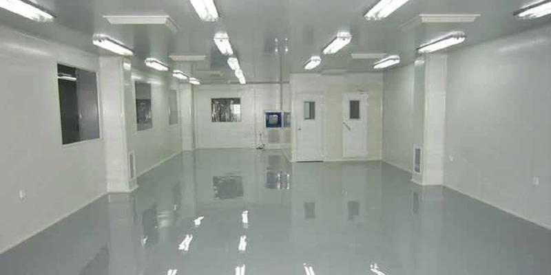 Glossy gray resin floor in an enclosed clean production room.